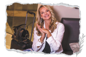 smart packing tips for carry on luggage adventures; Kim, The Abundant Traveler smiling in an airport with her carry on bag and purse