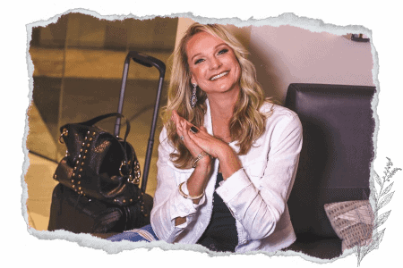 smart packing tips for carry on luggage adventures; Kim, The Abundant Traveler smiling in an airport with her carry on bag and purse