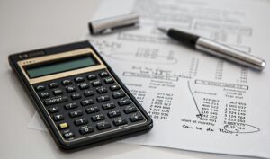 calculator with a budget sheet; how to budget your travel smartly