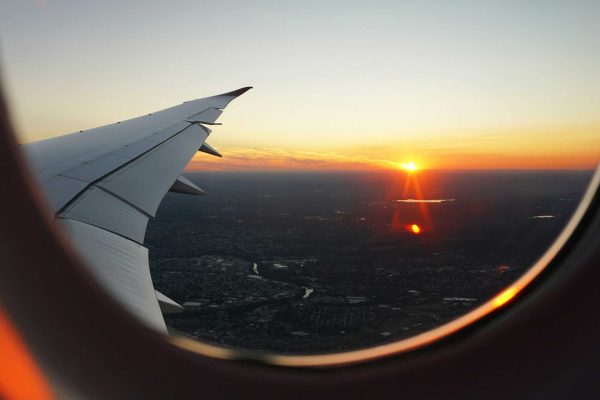 view from a plane window with the sunset; budget your travel