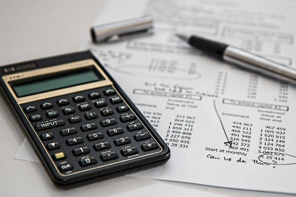 calculator with a budget sheet; how to budget your travel smartly